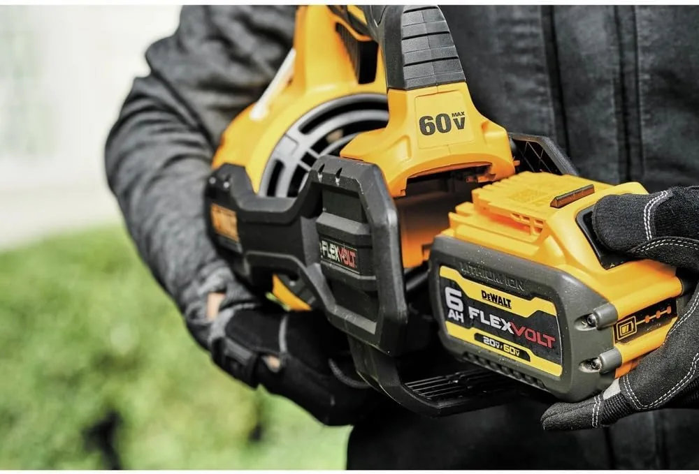 Battery bay of the DEWALT 60V MAX FLEXVOLT blower with a 6 Ah FLEXVOLT pack being fitted by a gloved hand