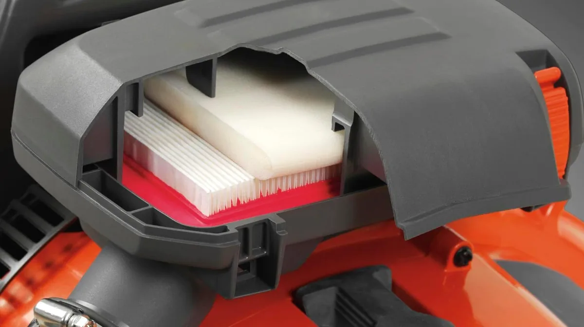 Open air filter housing on a Husqvarna backpack blower showing the pleated two-stage filter
